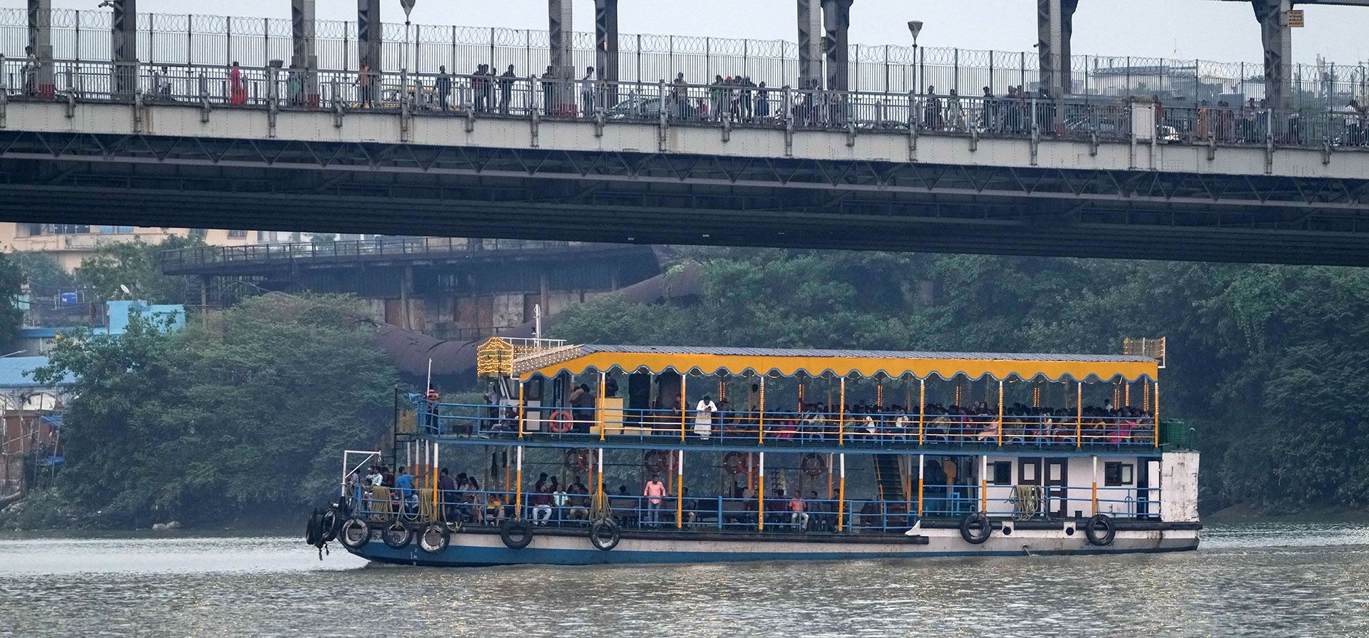 Un ferry turístico pasa por el puente Howrah en el río Hooghly en Calcuta, India, el martes 8 de noviembre de 2022.