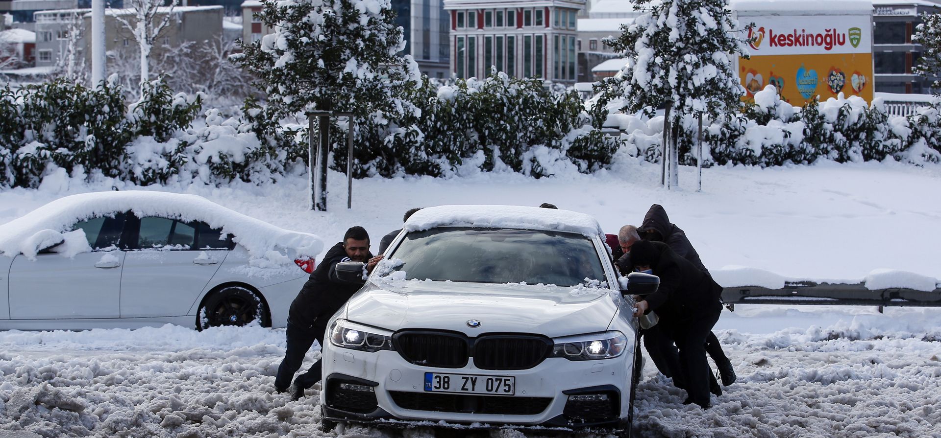 La gente empuja un automóvil en una calle cubierta de nieve en Estambul, el martes 25 de enero de 2022. Los equipos de rescate en Estambul y Atenas se apresuraron el martes para despejar las carreteras que quedaron paralizadas después de que un frente frío masivo y tormentas de nieve azotaran gran parte de Turquía y Grecia.