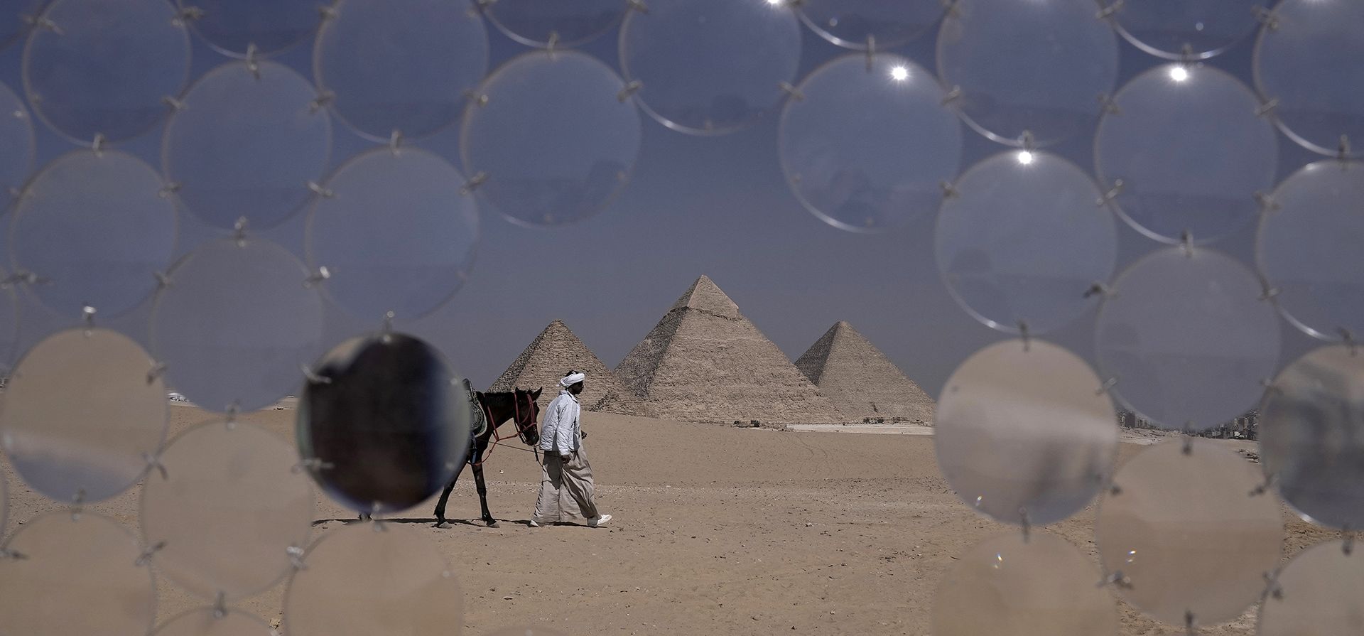 Un guía tira de su caballo frente a la instalación titulada Un guía tira de su caballo frente a la instalación titulada