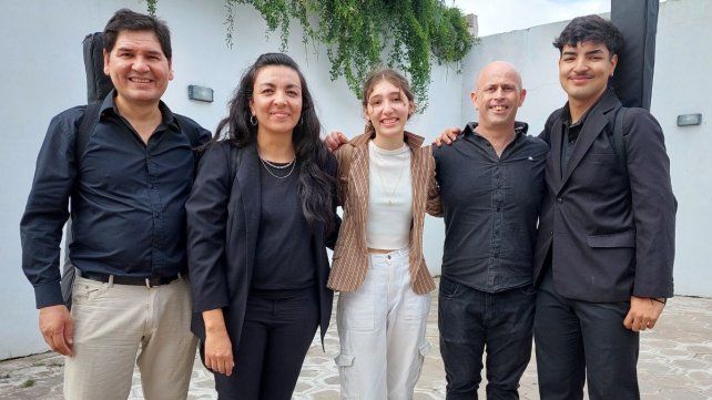 En el medio Candela Heis acompañada de su equipo musical&nbsp;