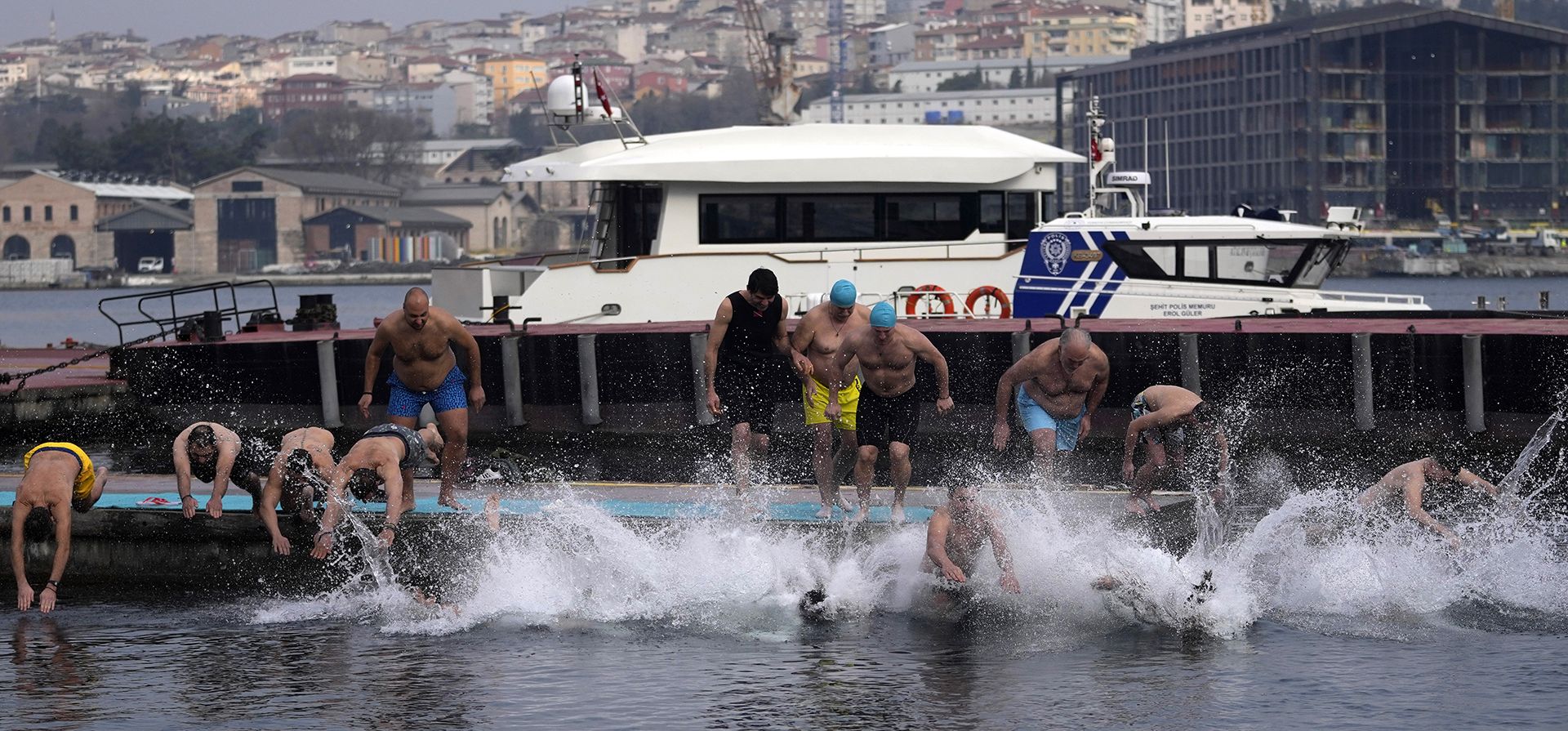Fieles ortodoxos griegos saltan al agua para recuperar un crucifijo de madera después de arrojarlo al Cuerno de Oro durante el día de la Epifanía en Estambul, Turquía, el viernes 6 de enero de 2023. (Foto AP/Khalil Hamra)