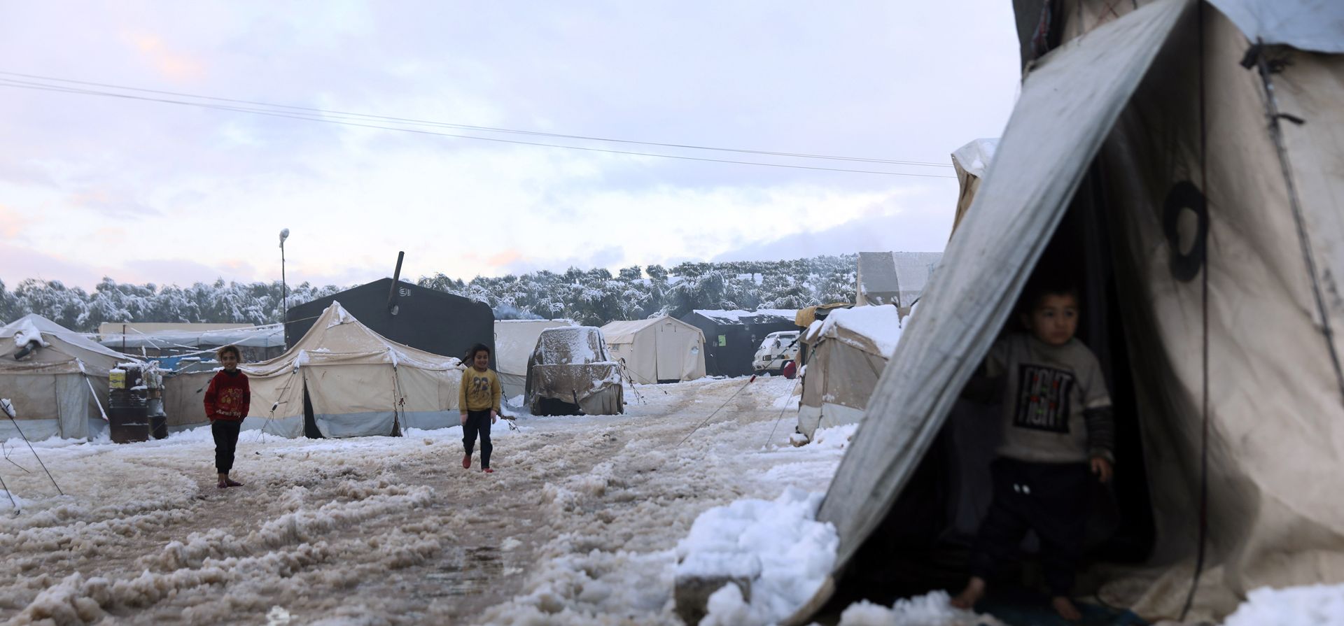Niños sirios desplazados caminan sobre la nieve en un campo de refugiados en Afrin, al norte de Alepo, Siria, el miércoles 19 de enero de 2022. Una tormenta de nieve en el Medio Oriente ha dejado a muchos libaneses y sirios luchando por encontrar formas de sobrevivir.