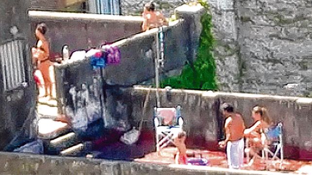 solarium. Al menos cuatro adultos y dos ni&ntilde;os toman sol en la terraza de un edificio c&eacute;ntrico.