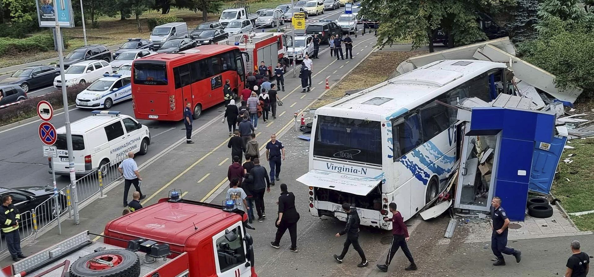 La policía escolta a los migrantes para abordar un autobús en la escena de un incidente, en la ciudad de Burgas, Bulgaria, en el Mar Negro, el jueves 25 de agosto de 2022. El Ministerio del Interior de Bulgaria dice que dos policías murieron mientras intentaban detener un autobús con migrantes que habían ingresado ilegalmente al país.