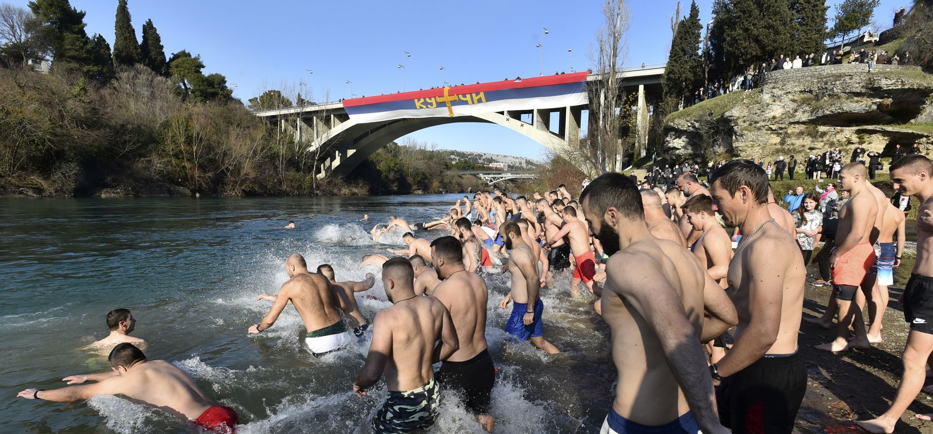 Creyentes cristianos ortodoxos saltan al agua fría del río Moraca, en Podgorica, Montenegro, el miércoles 19 de enero de 2022. Los serbios ortodoxos celebran la Epifanía el 19 de enero, siguiendo el antiguo calendario juliano, con la tradicional recuperación de cruces de los ríos y lagos.
