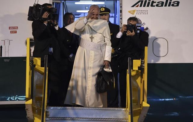 Saludo. El pontífice se despide desde la escalinata del avión de Alitalia. El viento le arrancó el solideo de la cabeza.