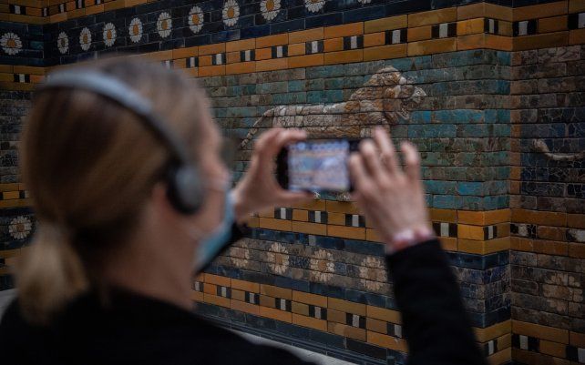 Una turista toma una foto de la ruta procesional que pertenece a la Puerta de Ishtar en el Museo de Pérgamo, Berlín. Después del cierre por el coronavirus, algunos museos han reabierto a los visitantes.