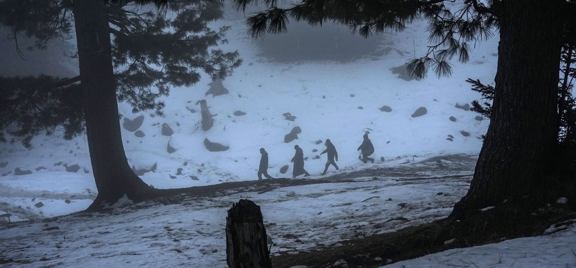 Trabajadores de Cachemira caminan a través de una densa niebla en una montaña cubierta de nieve cerca de Gulmarg, al noroeste de Srinagar, en la Cachemira india, el martes 10 de enero de 2023. (Foto AP/Mukhtar Khan)