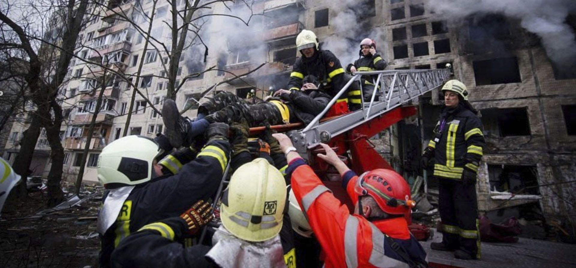 Foto publicada por el servicio de prensa del Servicio Estatal de Emergencias de Ucrania, los bomberos evacuan a un hombre de un edificio de apartamentos alcanzado por los bombardeos en Kiev, Ucrania, el lunes 14 de marzo de 2022.