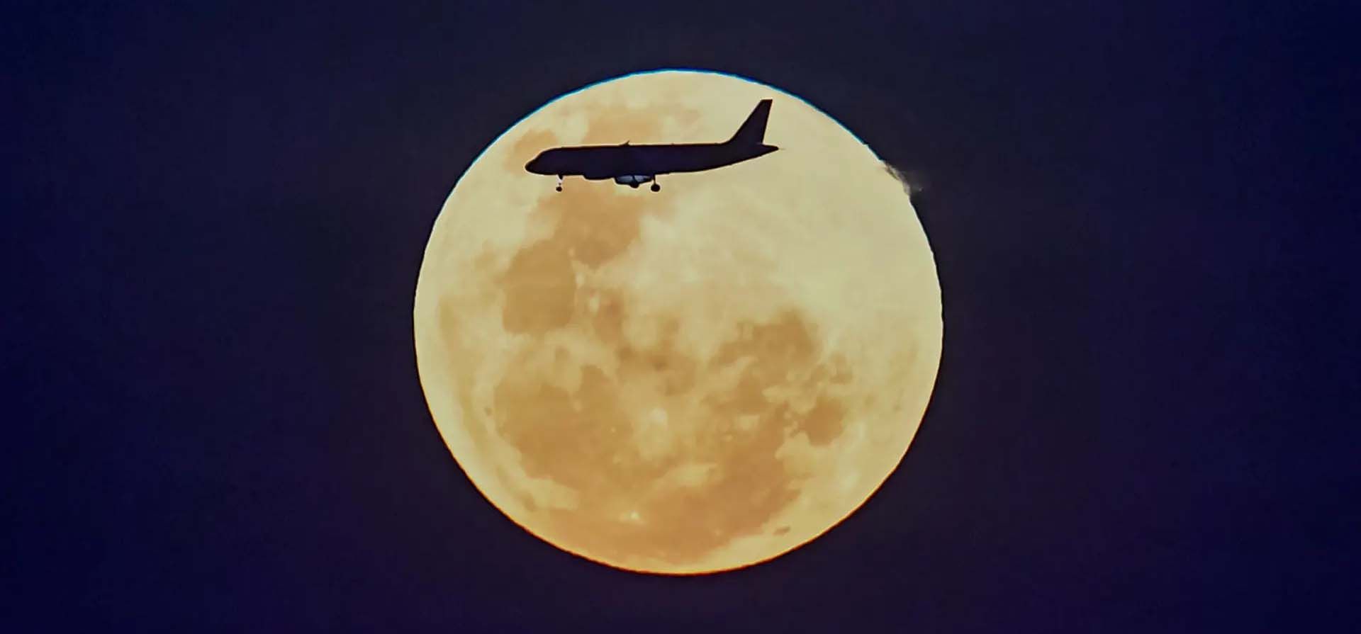 Un avión sobrevuela la luna llena creciente, conocida como luna de gusano. Fotografía: Roslan Rahman/AFP/Getty Images Un avión sobrevuela la luna llena creciente, conocida como luna de gusano. Fotografía: Roslan Rahman/AFP/Getty Images