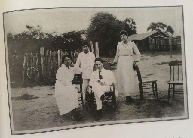 Un directivo de la empresa de explotación de quebracho posando con mujeres frente a un rancho.