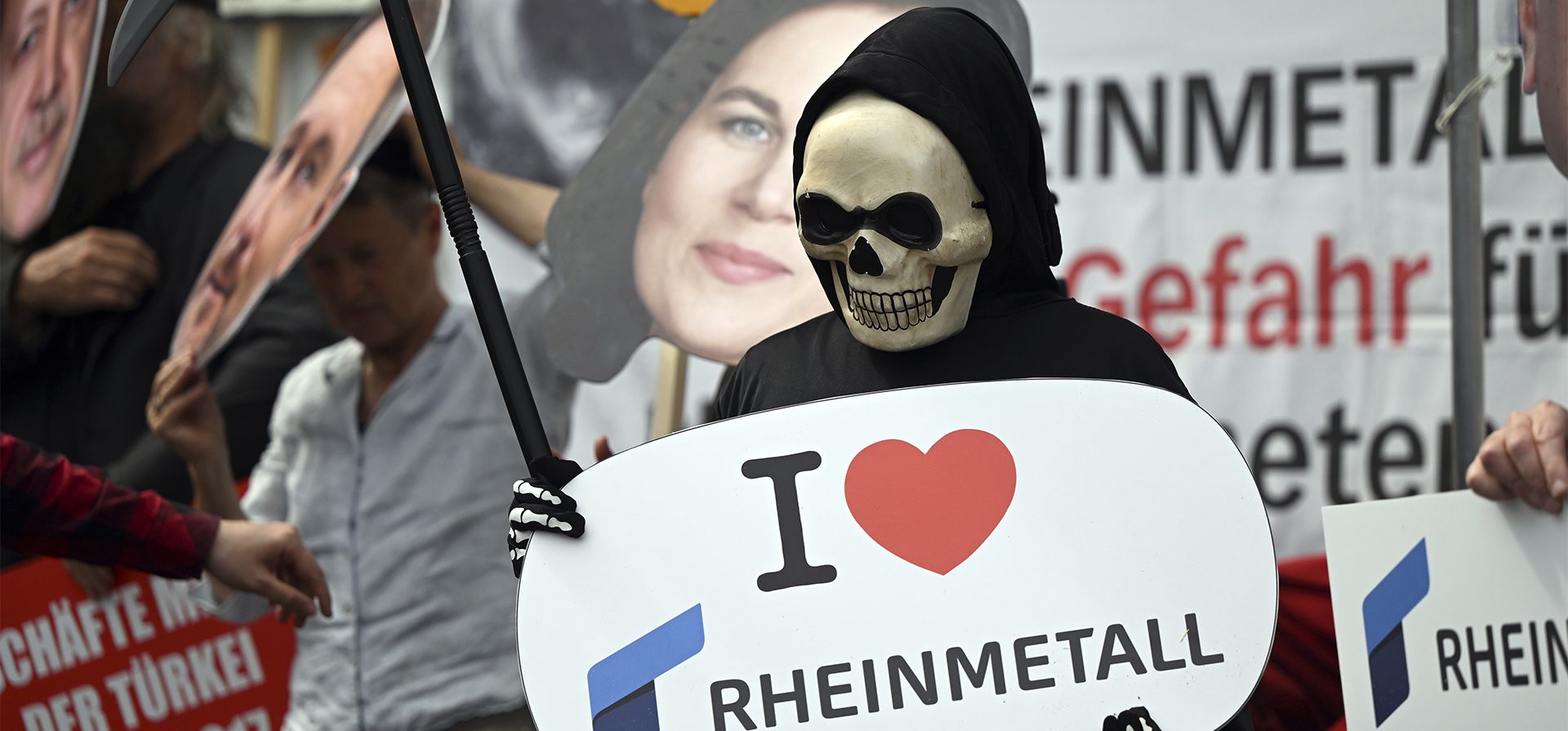 Un manifestante vestido como la Muerte sostiene un cartel que dice "Me encanta Rheinmetal" en Düsseldorf, Alemania, el martes 10 de mayo de 2022. El fabricante de tanques y artillería Rheinmetall espera duplicar su negocio con las fuerzas armadas en el futuro.