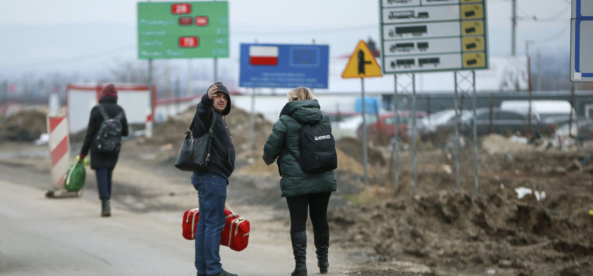 Refugiados ucranianos caminan por la carretera después de huir del país en el cruce fronterizo en Medyka, sureste de Polonia.