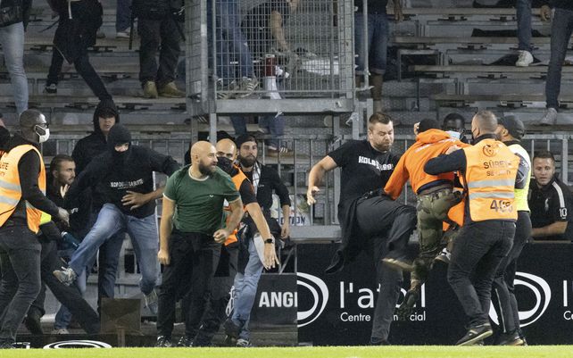 Aficionados del soccer chocan después de que los seguidores del Marsella invaden el campo durante el partido de fútbol de la Liga Uno entre Angers y Marsella, en el estadio Raymond-Kopa en Angers, en el oeste de Francia, el miércoles 22 de septiembre de 2021.