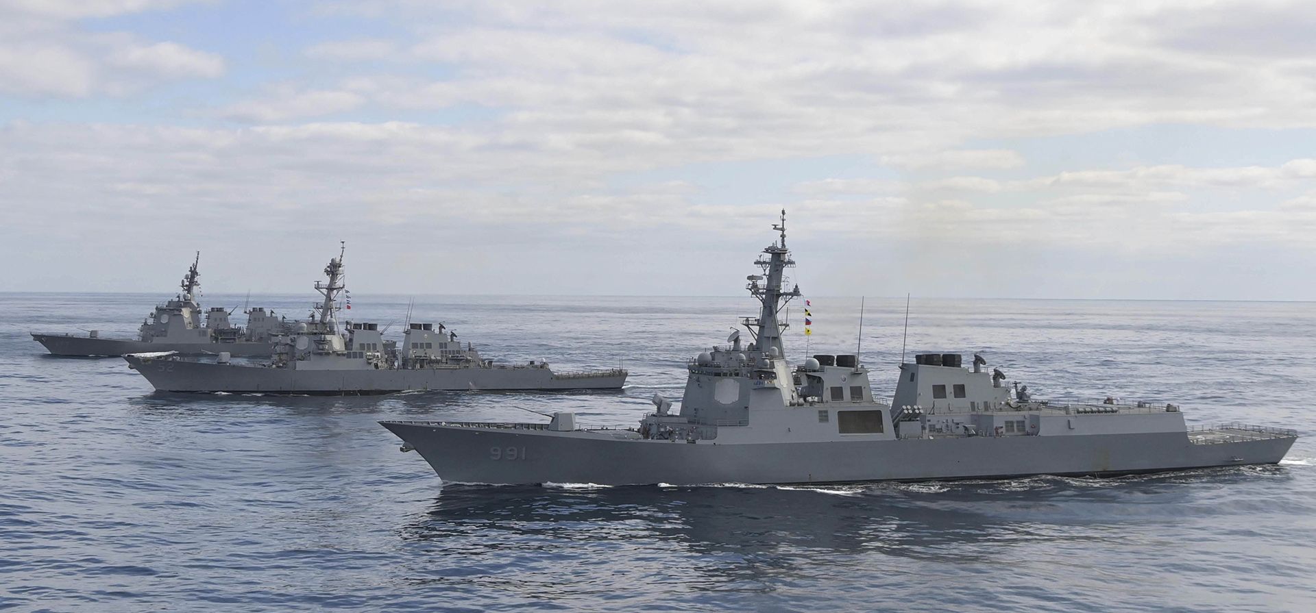 El destructor Aegis King Sejong the Great de la Armada de Corea del Sur, al frente, navega con el destructor de misiles guiados USS Barry de la clase Arleigh Burke de la Armada de los EE. UU., en el centro, y el destructor Atago de la Fuerza Marítima de Autodefensa de Japón, arriba. , durante un simulacro conjunto de defensa antimisiles entre Corea del Sur, Estados Unidos y Japón en las aguas internacionales de la costa este de la península coreana, el miércoles 22 de febrero de 2023. (Ministerio de Defensa de Corea del Sur vía AP)