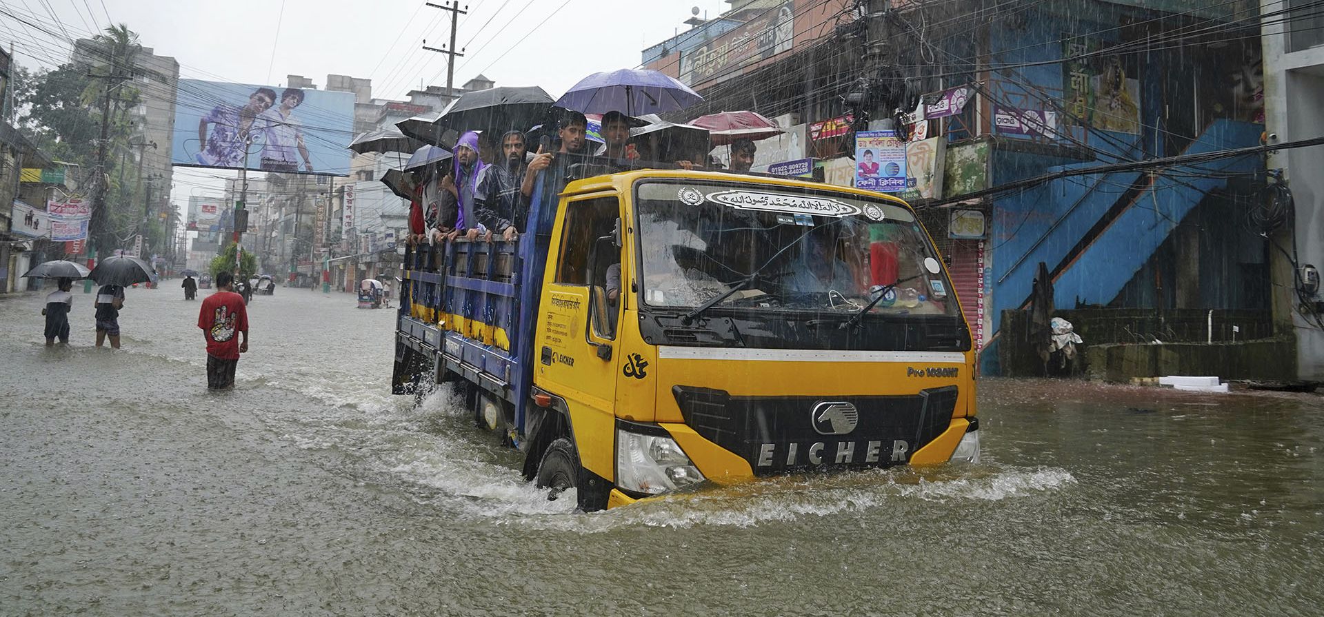 Varias personas viajan en la parte trasera de un vehículo mientras recorren una calle inundada tras las incesantes lluvias en Feni, un distrito costero en el sureste de Bangladesh que limita con el estado indio de Tripura, Bangladesh, el jueves 22 de agosto de 2024. (Foto AP) Varias personas viajan en la parte trasera de un vehículo mientras recorren una calle inundada tras las incesantes lluvias en Feni, un distrito costero en el sureste de Bangladesh que limita con el estado indio de Tripura, Bangladesh, el jueves 22 de agosto de 2024. (Foto AP)