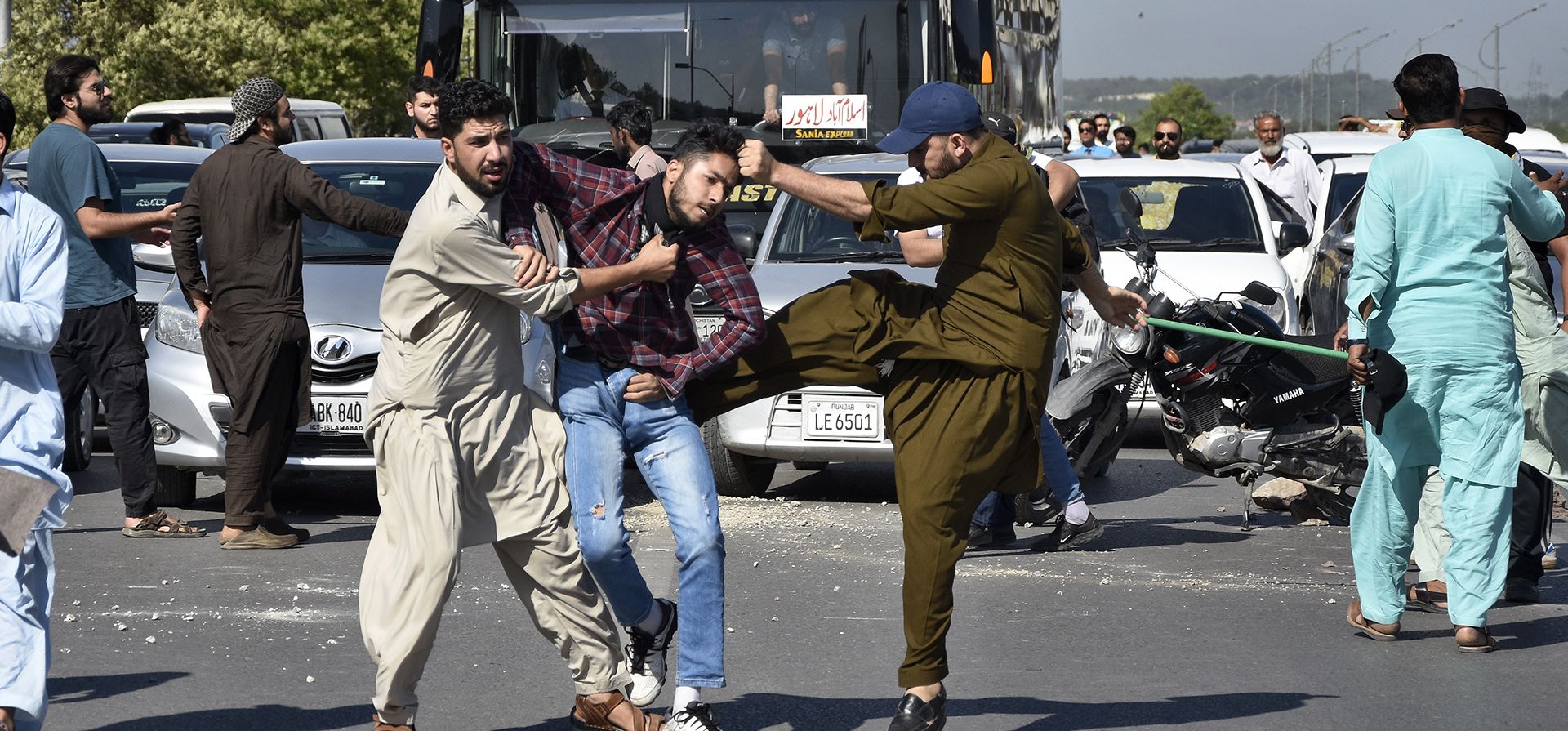 Policías vestidos de civil golpean a un partidario del ex primer ministro de Pakistán, Imran Khan, mientras lo detienen cuando él y otros bloquean una carretera como protesta para condenar el arresto de su líder, en Peshawar, Pakistán, el martes 9 de mayo de 2023. (Foto AP/W.K. Yousufzai)