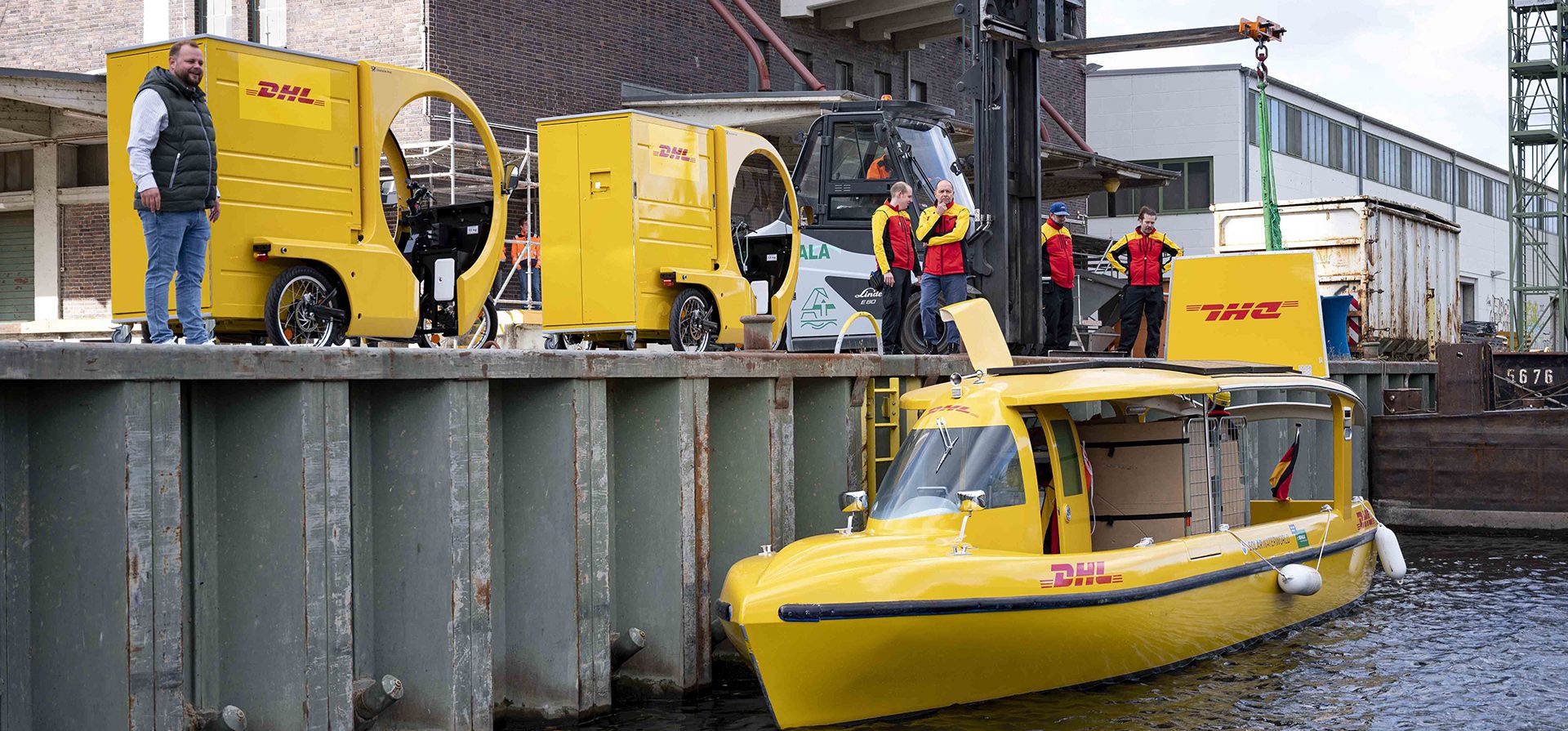 Empleados descargan un barco solar de Deutsche Post DHL en