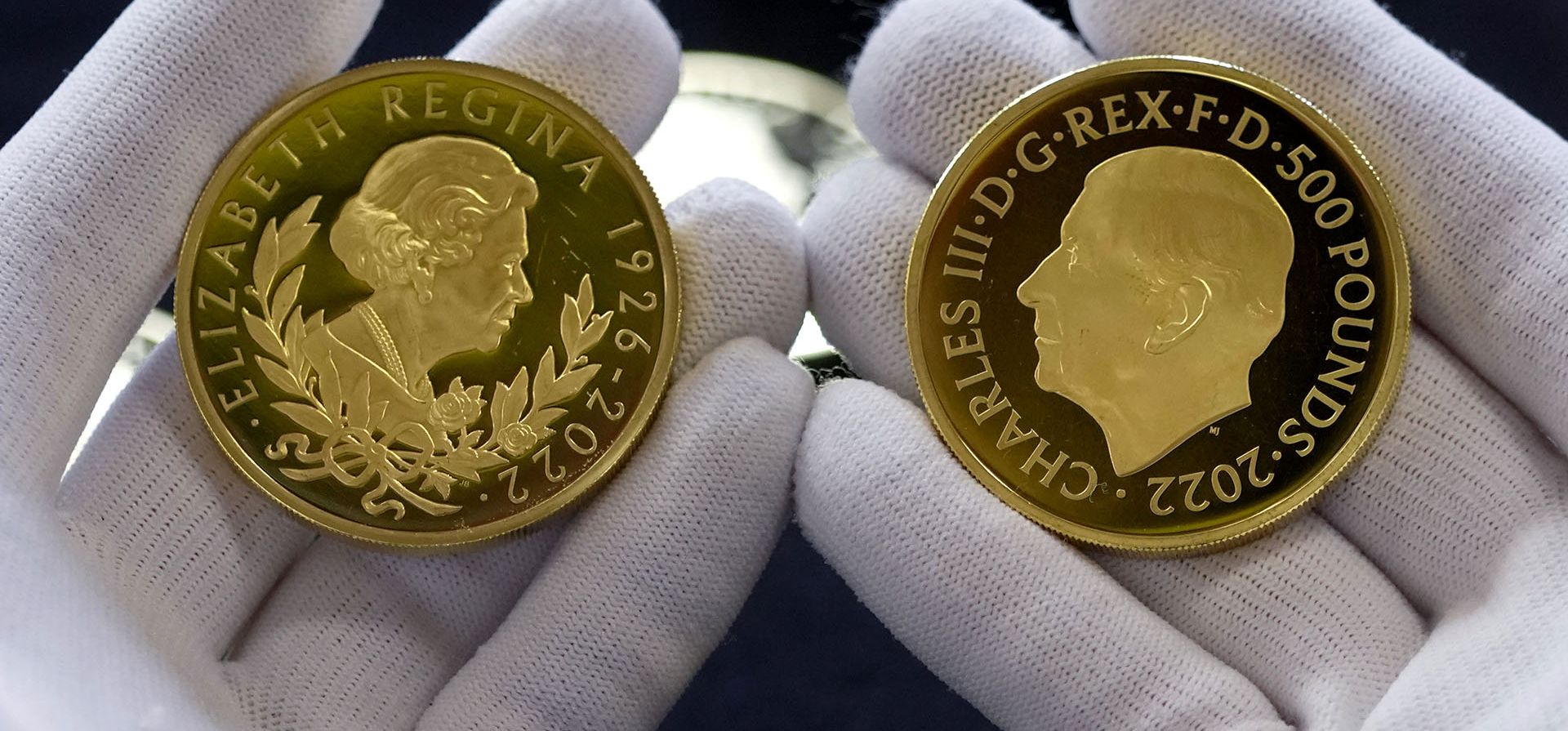 Las monedas con los retratos del rey Carlos III, a la derecha, y de la reina Isabel II, se evalúan durante el "Juicio del copón", una ceremonia que data del siglo XII en la que se pesan las monedas para asegurarse de que estén en buen estado, en el Goldsmiths