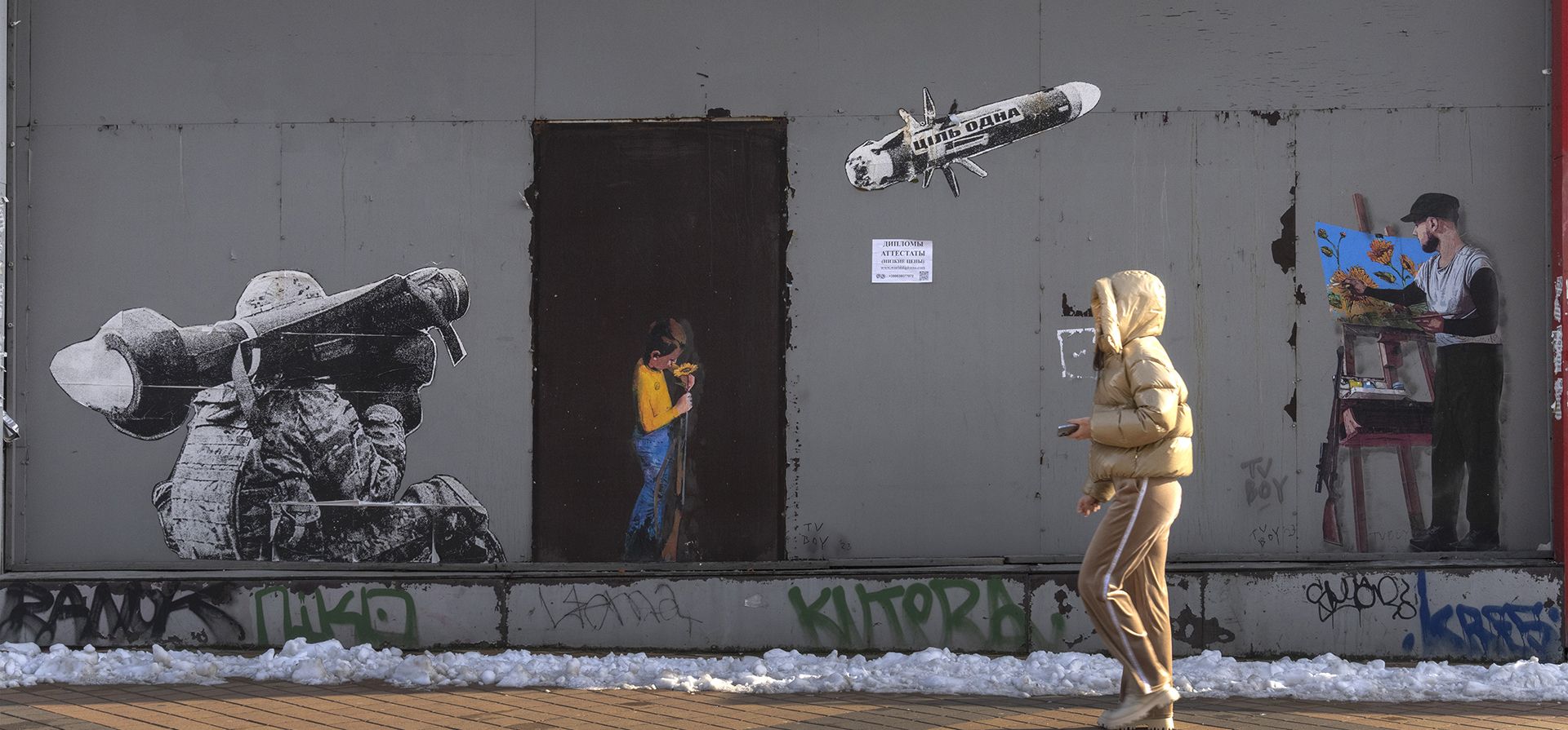 Una mujer pasa junto a una obra de arte del famoso artista callejero TvBoy creada sobre un grafiti antiguo que representa a un soldado ucraniano disparando un misil antitanque. La escritura en el misil dice: "El objetivo es uno", en Kyiv, Ucrania, el miércoles 1 de febrero de 2023. (Foto AP/Efrem Lukatsky)