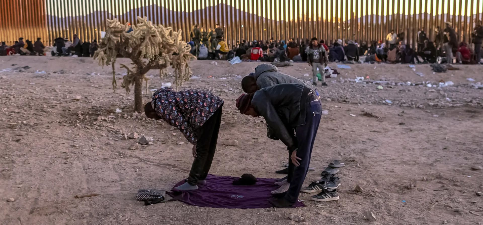 Personas de Senegal rezan al atardecer mientras esperan ser transportadas desde la frontera entre Estados Unidos y México para su procesamiento, Lukeville, Arizona. Fotografía: John Moore/Getty Image