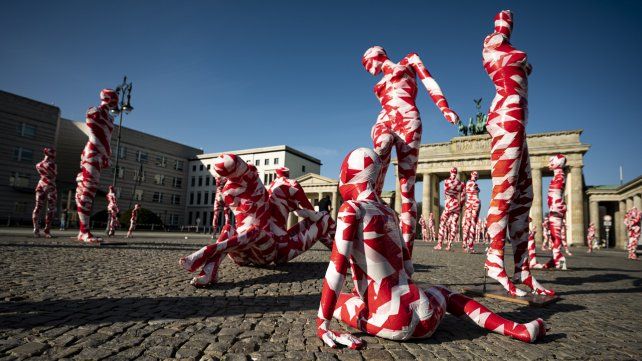 Maniquíes cubiertos con cinta de barrera se colocan frente a la Puerta de Brandenburgo, como parte de la instalación de arte