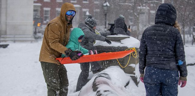 Familias juegan con sus hijos durante la tormenta de nieve en Washington Square Park en Nueva York. 