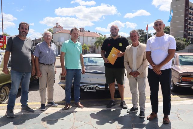 Autoridades provinciales y representantes de clubes de autos antiguos durante la entrega de patentes y permisos de circulación para vehículos históricos, realizada en la ciudad de Santa Fe.