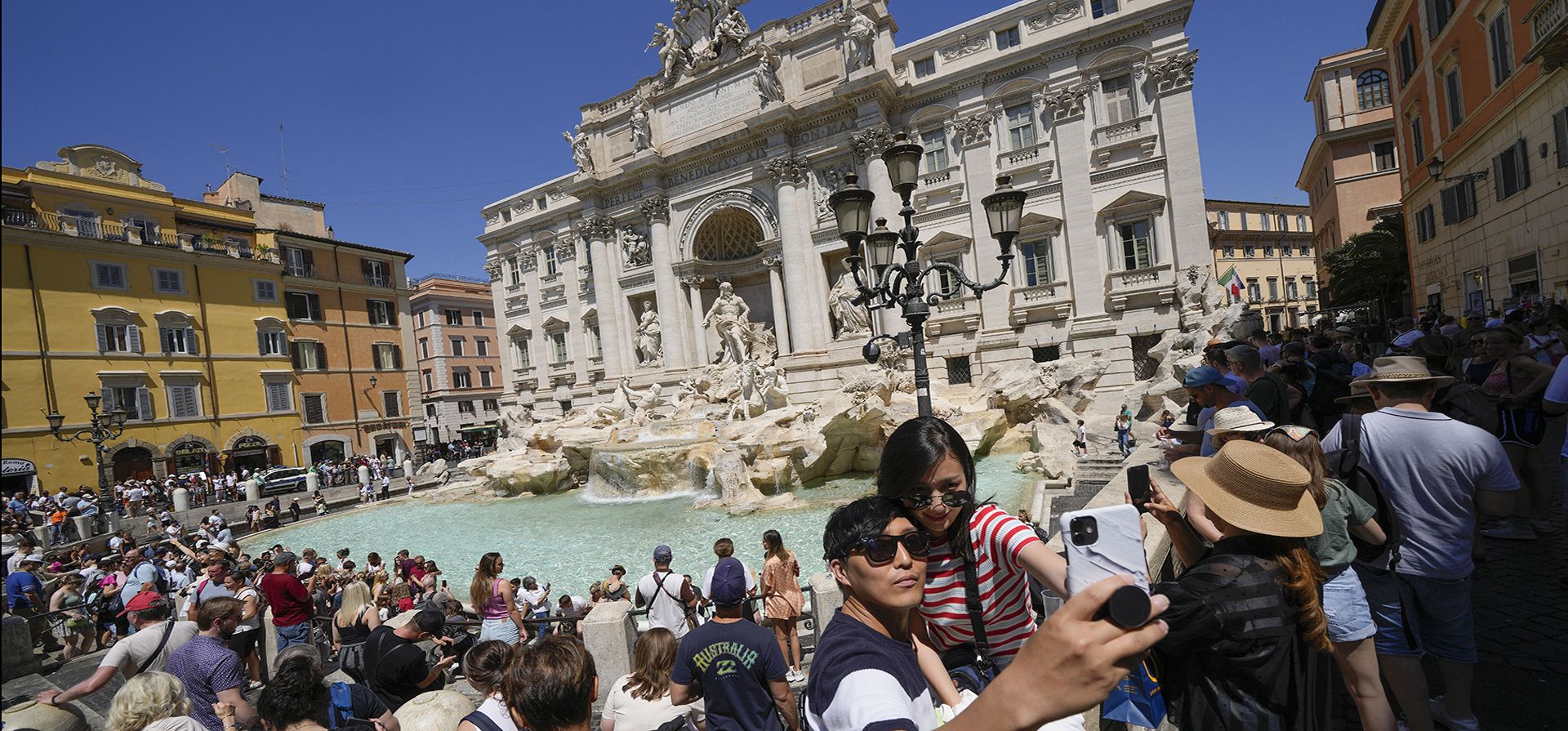Turistas se toman una selfie frente a la Fontana de Trevi, en Roma. Los viajes de verano están en marcha en todo el mundo, pero una recuperación completa de dos años de coronavirus podría durar tanto como la pandemia misma. En Italia, los turistas, especialmente de los EE. UU., regresaron este año en masa.