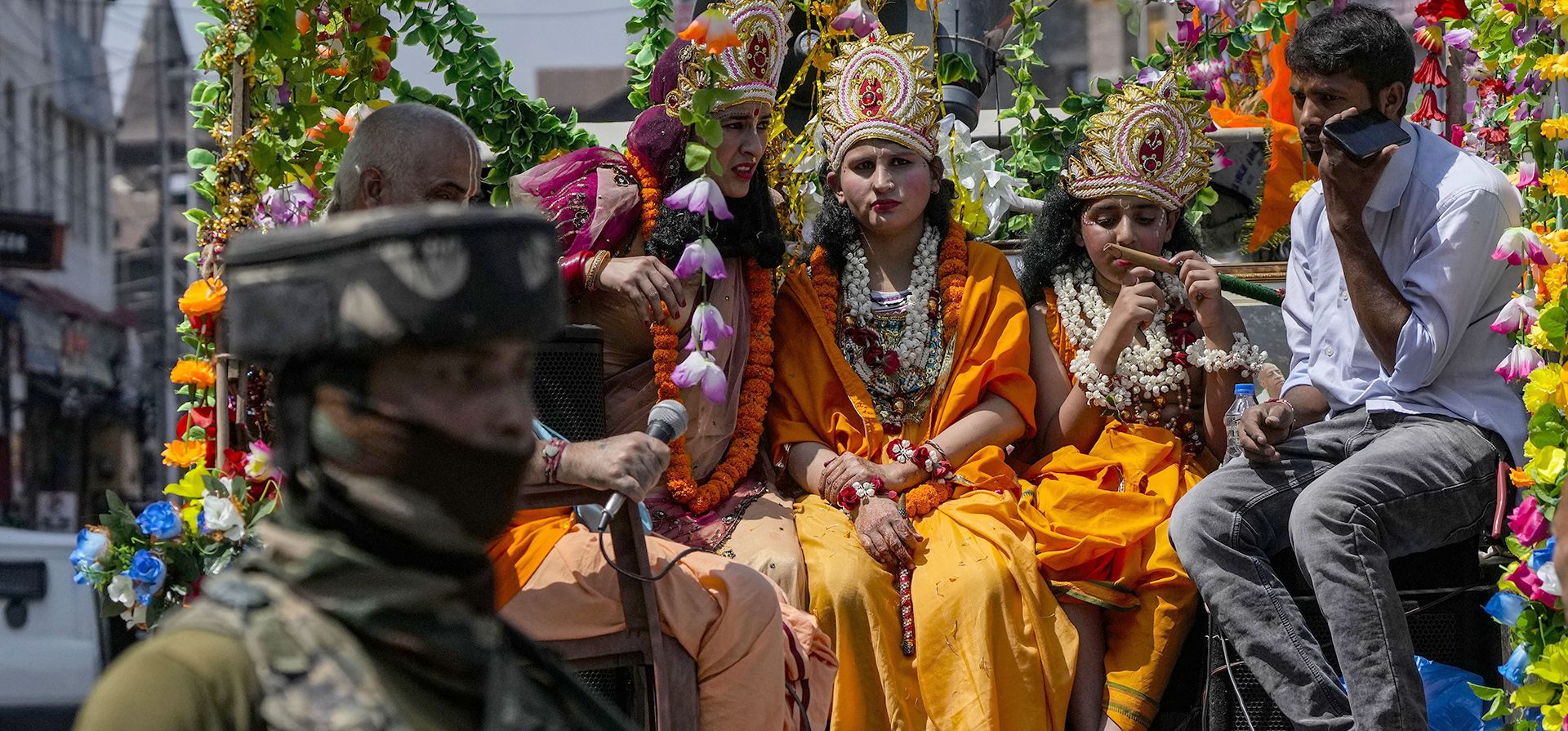 Un soldado vigila a los niños vestidos como las deidades hindúes Krishna, a la derecha, y Radha participan en una procesión para marcar