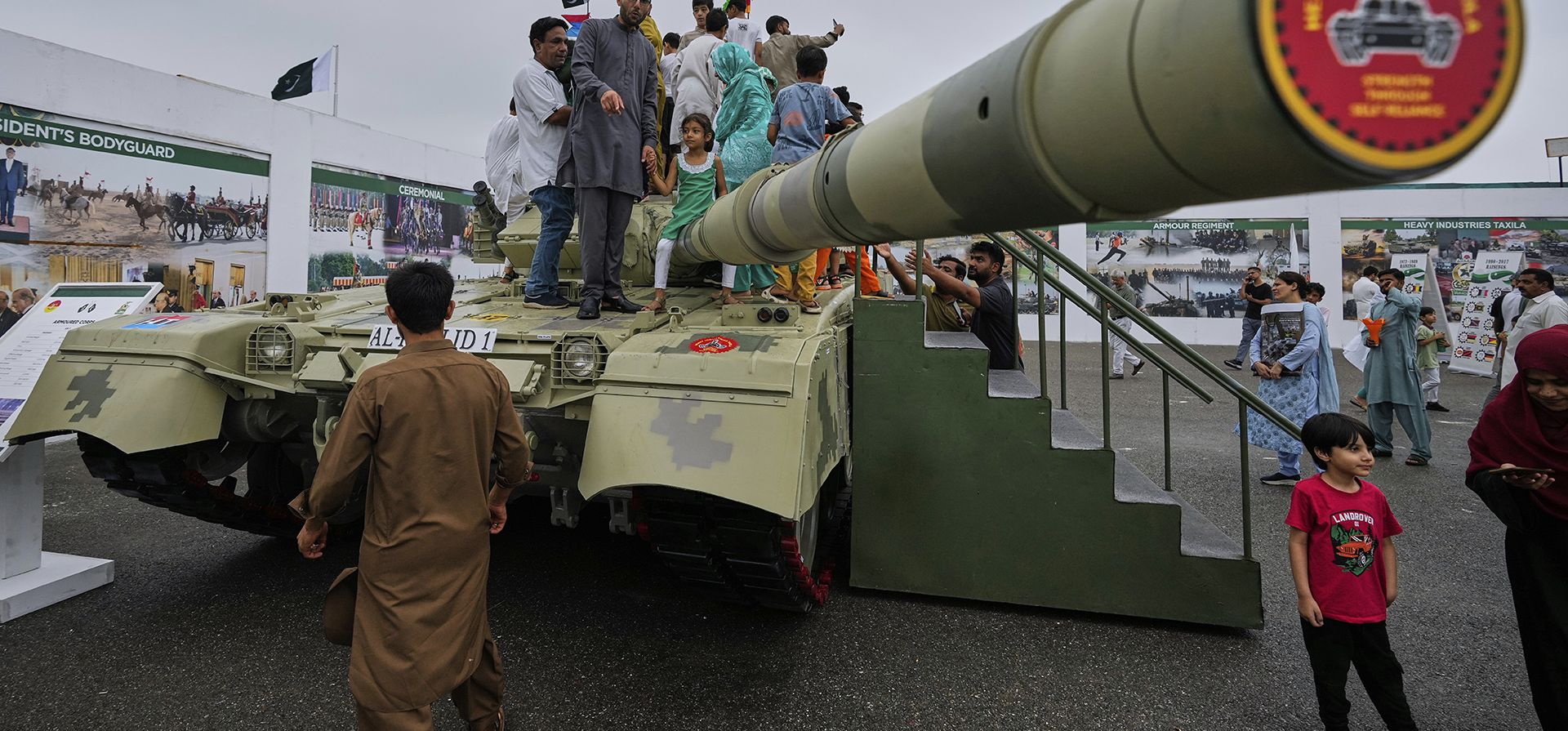 Familias junto a un tanque Al-Khalid, fabricado en Pakistán, durante una exhibición de defensa celebrada en el marco de las celebraciones del Día de la Independencia de Pakistán, en Islamabad, Pakistán, el jueves 14 de agosto de 2025. (Foto AP/Anjum Naveed)