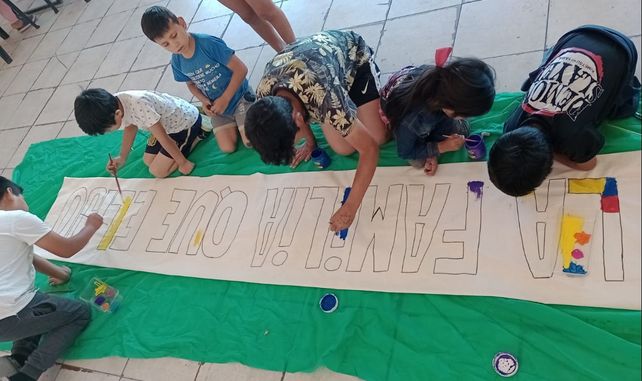 Los niños y niñas del barrio Qom de Travesía pintar un cartel para celebrar este martes el Dìa de la Familia.&nbsp;