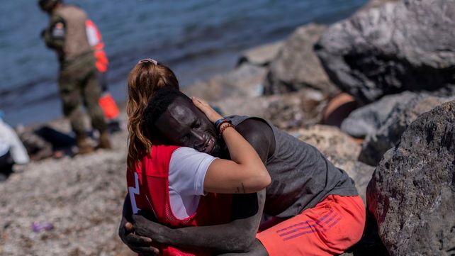 El emotivo abrazo de una voluntaria con un migrante.