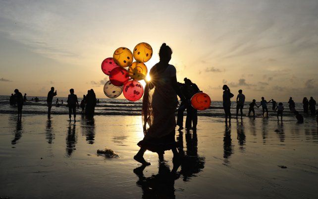 Una mujer vende globos en una playa de Juhu en Mumbai, India, el martes 24 de agosto de 2021.