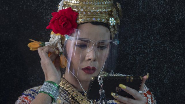 Una bailarina clásica tailandesa usa su teléfono móvil durante un descanso en el Santuario Erawan en Bangkok, Tailandia.
