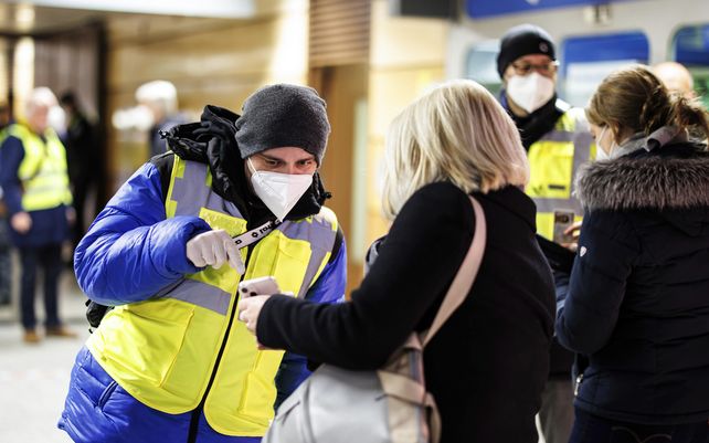 Un inspector de la empresa de transporte público de Múnich verifica el certificado de vacunación COVID-19 digital de un pasajero en la entrada de la estación de metro de Stachus
