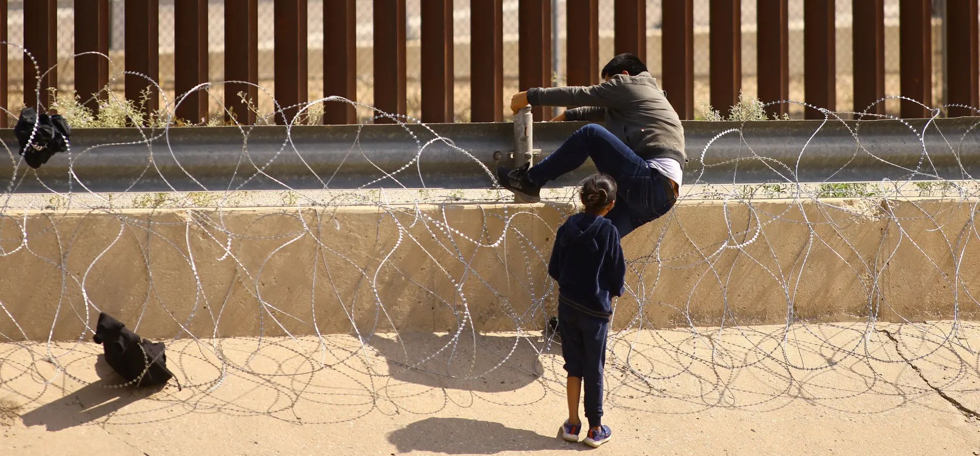 Ciudad Juárez, México. Migrantes intentan atravesar una cerca de alambre de púas erigida para evitar el cruce de migrantes a los Estados Unidos. Fotografía: José Luis González/Reuters Ciudad Juárez, México. Migrantes intentan atravesar una cerca de alambre de púas erigida para evitar el cruce de migrantes a los Estados Unidos. Fotografía: José Luis González/Reuters