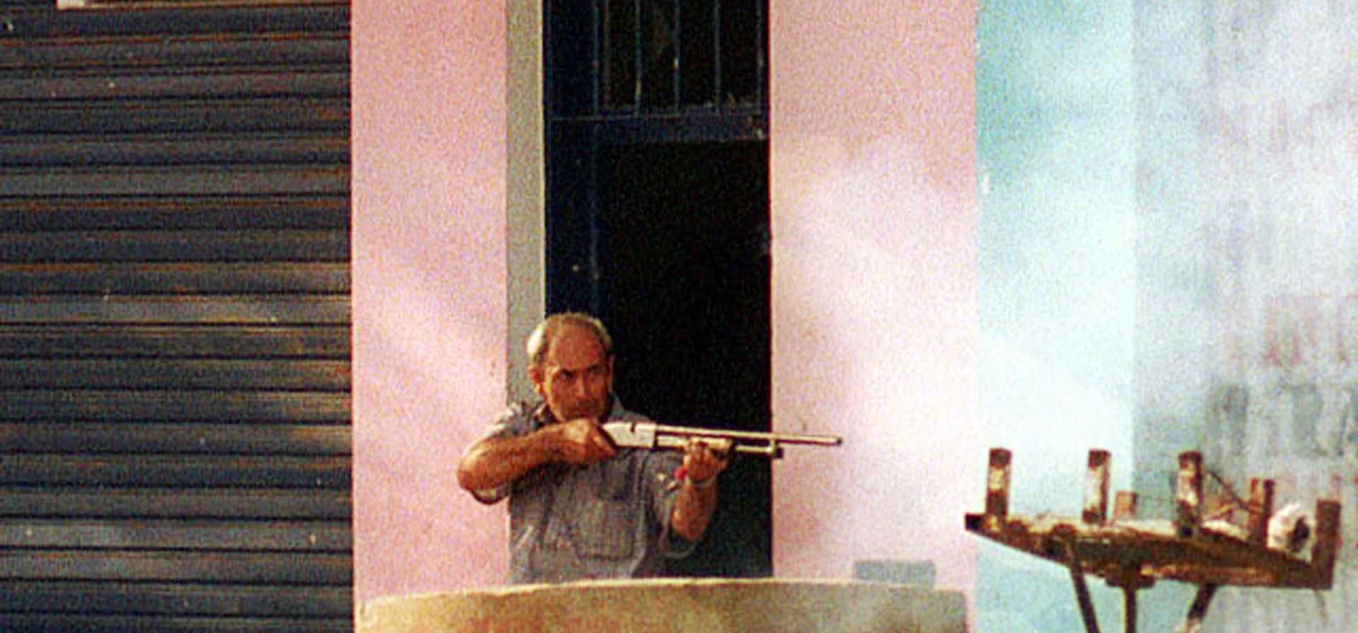 19/12/2001. Un comerciante de Villa Gobernador Gálvez se defiende de los saqueos con una Itaka poniendo en riesgo su vida y la de los manifestantes.