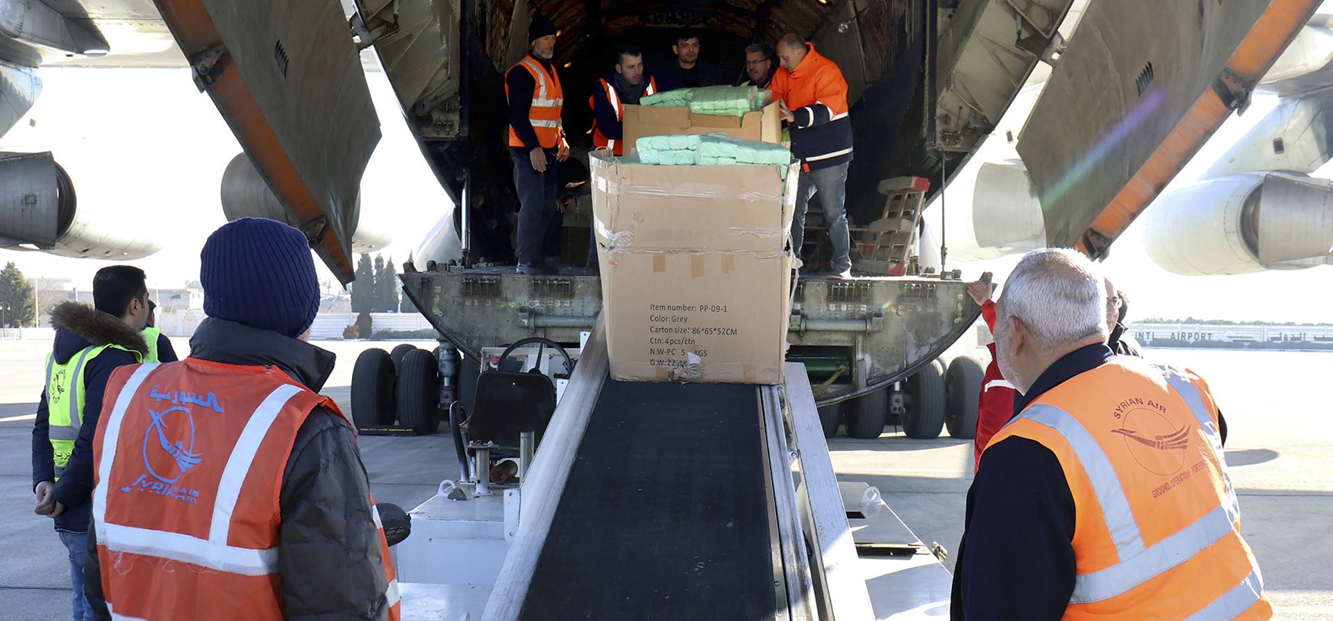 Trabajadores descargan ayuda humanitaria enviada desde Arminia, para Siria luego de un devastador terremoto, en el aeropuerto de Alepo, Siria, el jueves 9 de febrero de 2023. (SANA vía AP)