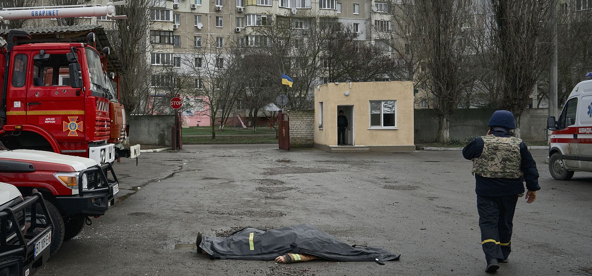 Un bombero pasa junto al cadáver de un compañero muerto en el bombardeo ruso de la estación de bomberos en Kherson, Ucrania, en la Nochebuena ortodoxa, el viernes 6 de enero de 2023. (Foto AP/LIBKOS)