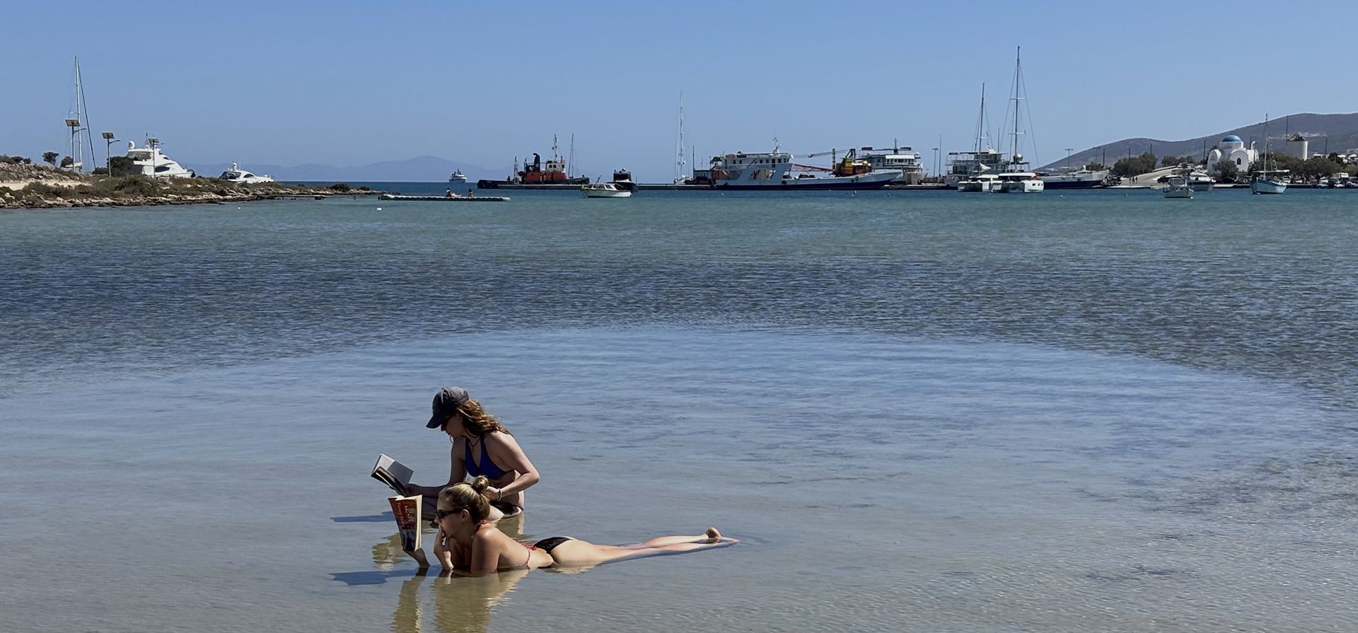 Dos turistas leen libros mientras se refrescan en el mar en Antiparos, una pequeña isla en el sur del Egeo, Grecia, durante un día caluroso el viernes 4 de julio de 2025. (Foto AP/Thanassis Stavrakis) Dos turistas leen libros mientras se refrescan en el mar en Antiparos, una pequeña isla en el sur del Egeo, Grecia, durante un día caluroso el viernes 4 de julio de 2025. (Foto AP/Thanassis Stavrakis)