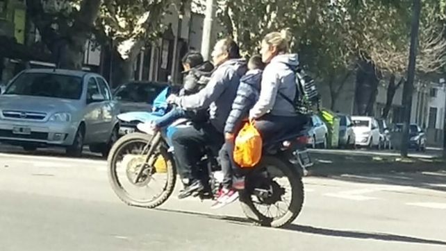 inconsciencia vial. Una familia de cuatro integrantes circula en moto sin casco por una calle de Rosario.