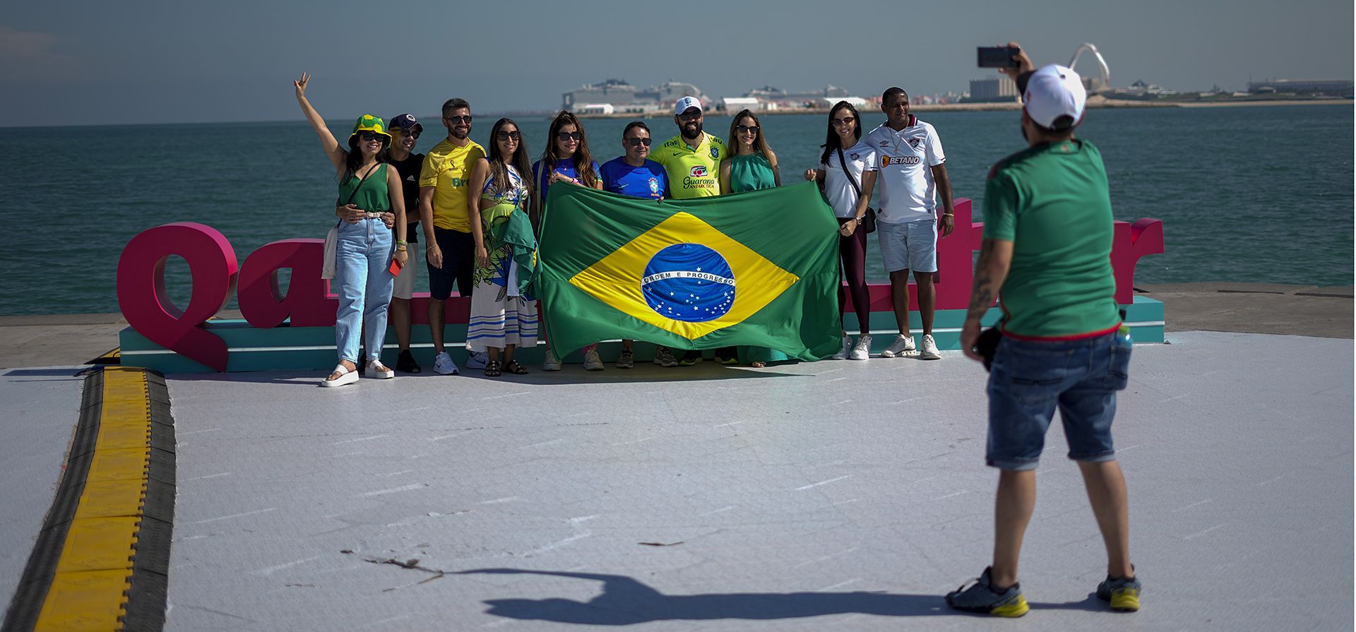Aficionados de la selección de fútbol de Brasil se toman una foto junto a la cornisa de Doha en Qatar, el miércoles 23 de noviembre de 2022.