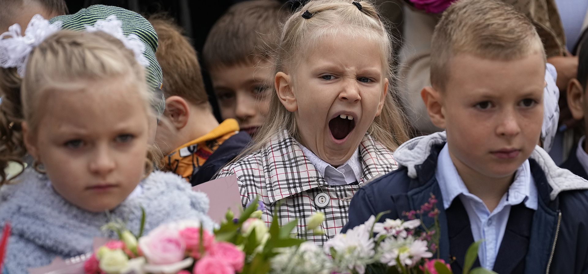 Escolares, la mayoría de ellos de primer grado, participan en una ceremonia que marca el inicio de clases en una escuela como parte de la apertura tradicional del año escolar conocido como
