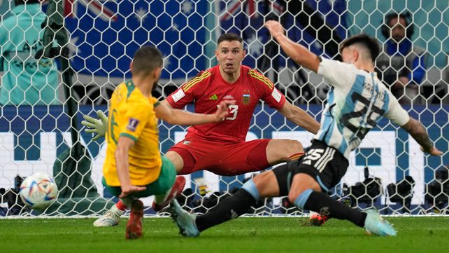 Aziz Behich intenta sacar el remate y sentenciar al Dibu Martínez