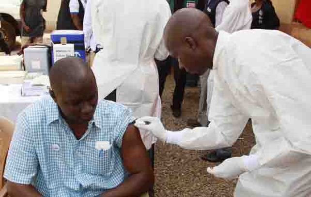 Guinea. Un trabajador de la salud aplica la dosis experimental a un habitante.