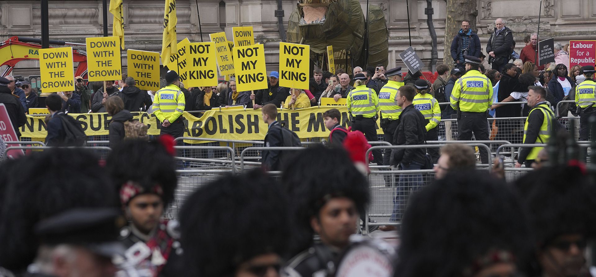 Manifestantes se reúnen con la mascota dinosaurio Chuck the Rex durante una protesta antes del inicio del servicio anual del Día de la Commonwealth en la Abadía de Westminster en Londres, el lunes 10 de marzo de 2025. (Foto AP/Alastair Grant)