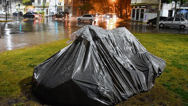 Bajo la lluvia. Algunos se guarecen como pueden.