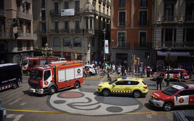 La policía acordona una calle céntrica de Barcelona para investigar la causa de una explosión. Miembros de los bomberos y de emergencias médicas