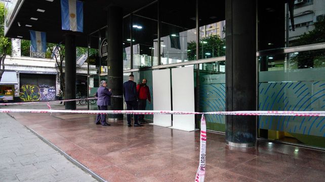 Personal del Banco Nación revisa la estructura provisoria donde estaba el vidrio chocado.
